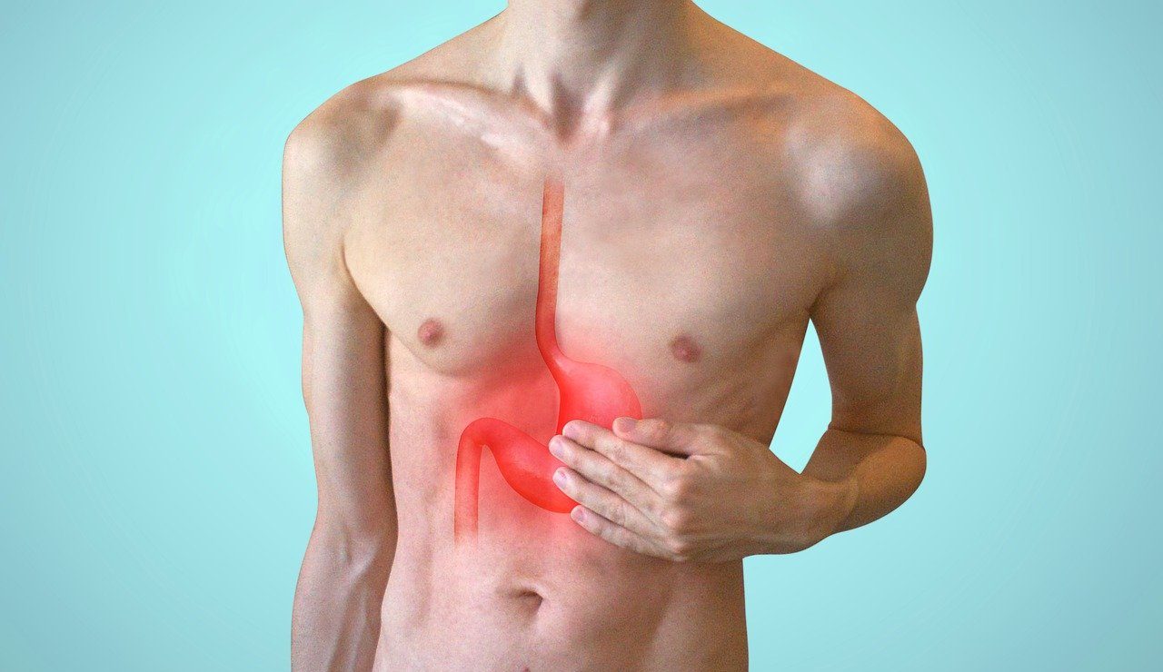 a man holds his upper stomach while a red outline of pain radiates in the shape of the organ